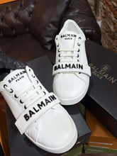 White Balmain sneakers on a black box with a blurred background